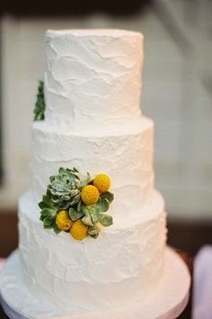 White cake with succulents and billy buttons