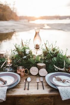 Rustic Table Wedding - metals - pottery - stoneware plates - hammered metal flatware - oil lamps - antlers - garland - wood ~ Styled by Wright Event Services Photography: Andrea Pesce Photography - www.andreapesceph... Read More: www.stylemepretty...