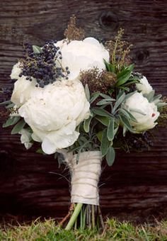 The bridal bouquet will be a loose clutch of ivory peonies, blue privet berries, green sage, white gardenias, rosemary, seeded eucalyptus and dusty miller wrapped in ivory linen.