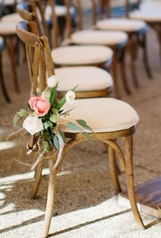 Brides.com: . To add a rustic touch to an otherwise formal affair, Frontier Flowers of Fontana created arrangements of pink peonies, blush roses, and white tulips, accented with antlers, to decorate seats along the aisle.