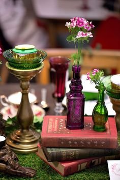 Glowing jewel toned glass and vintage books for a woodland themed wedding tablescape.  View the full whimsical Alice in Woodland Tea Party Wedding Styled Shoot on SingaporeBrides.